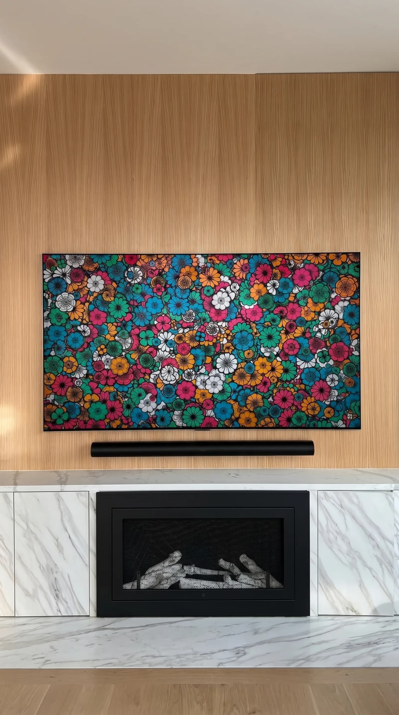 Frame TV with a soundbar mounted above a marble fireplace