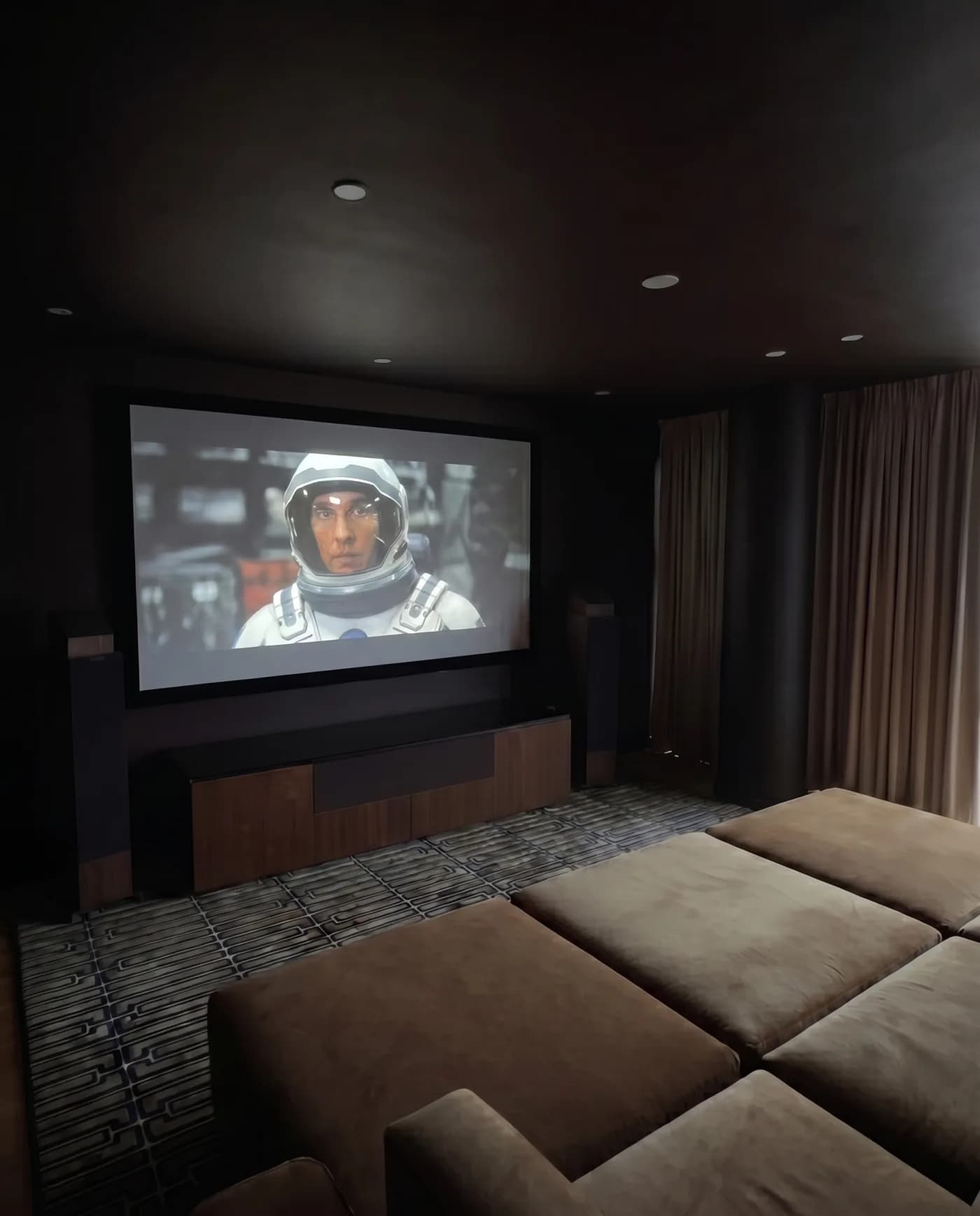 Dedicated NYC home theatre with tiered seating, tower speakers and a large screen