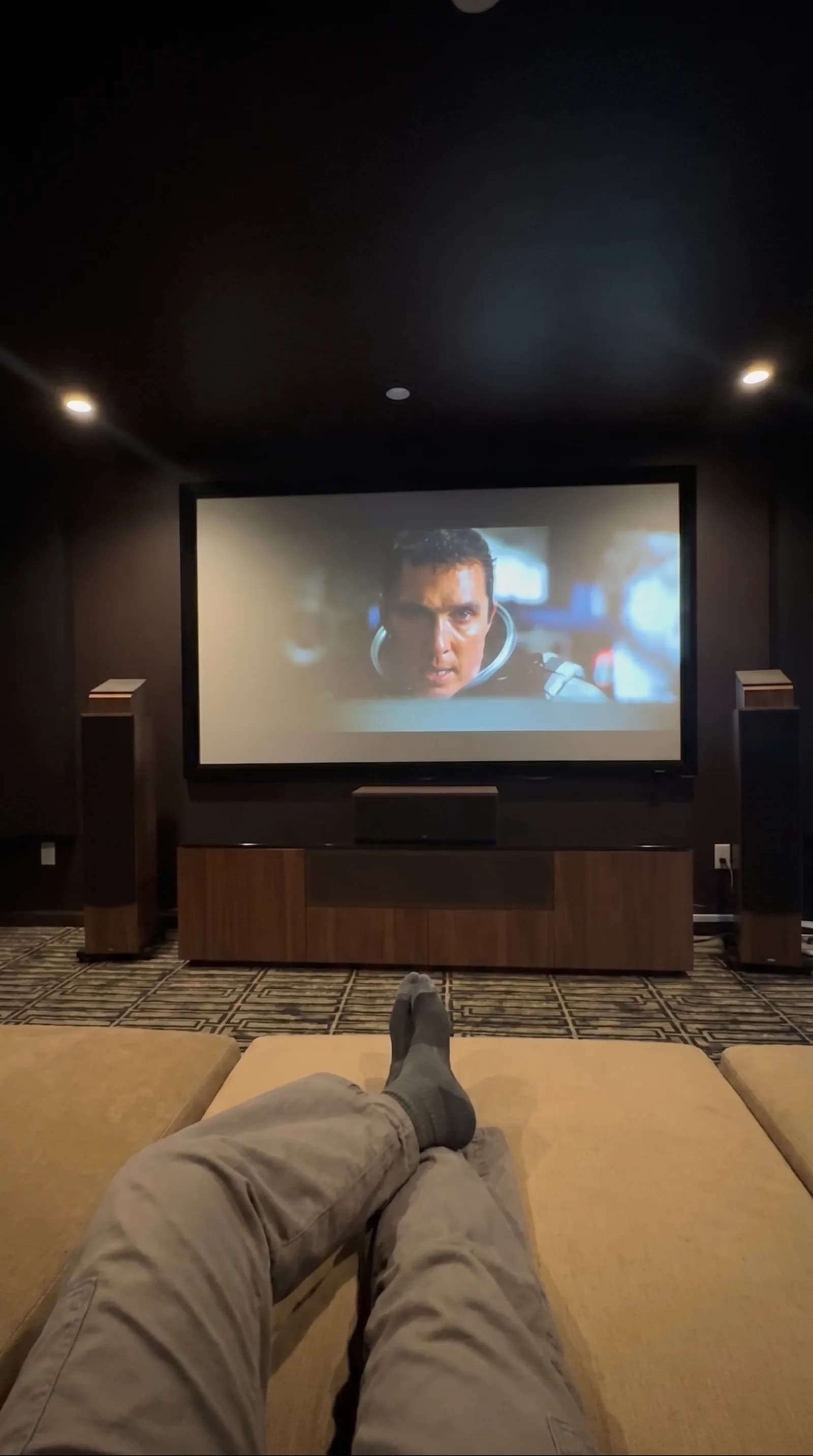 Home theatre point-of-view with feet up and a movie playing