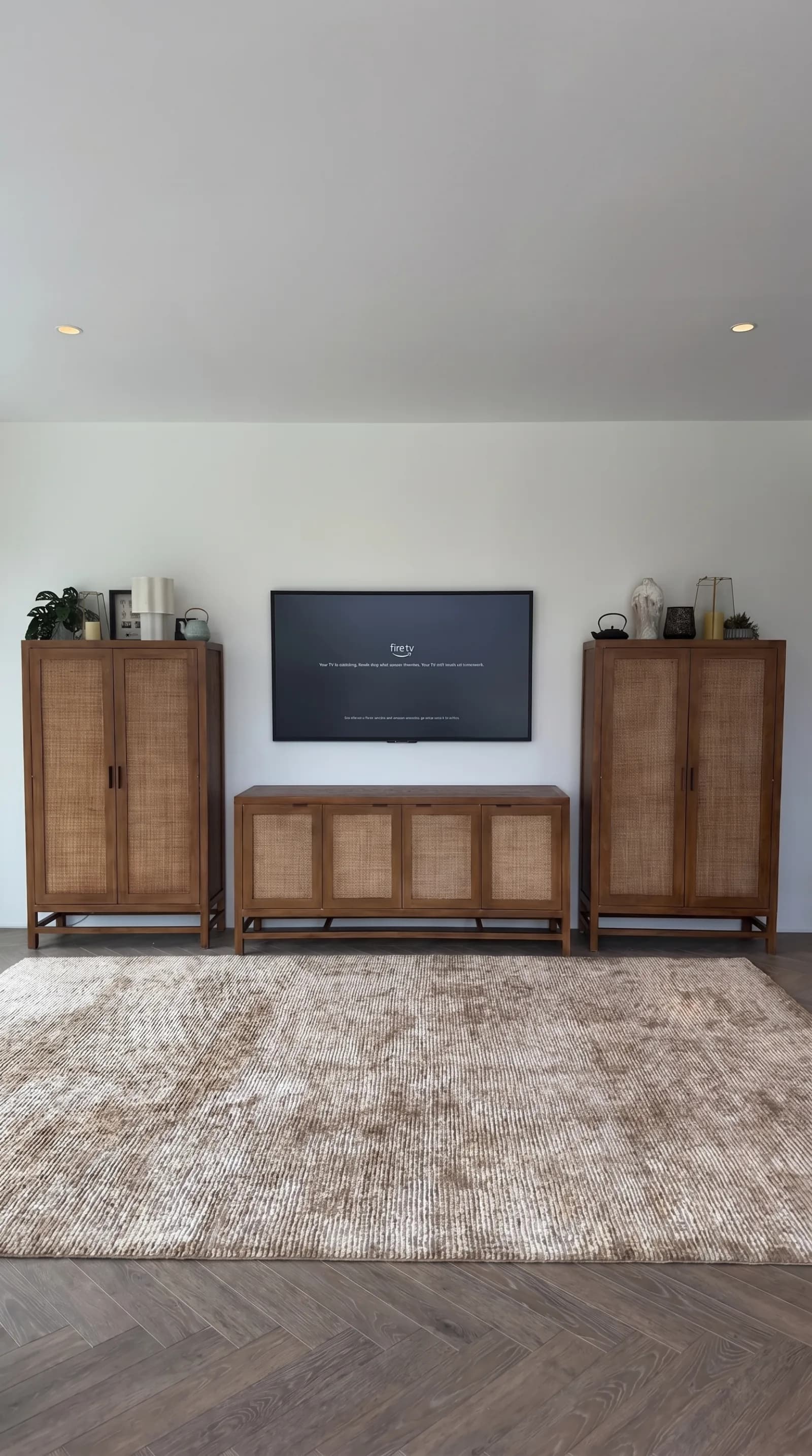 TV mounted between rattan cabinets in a living room