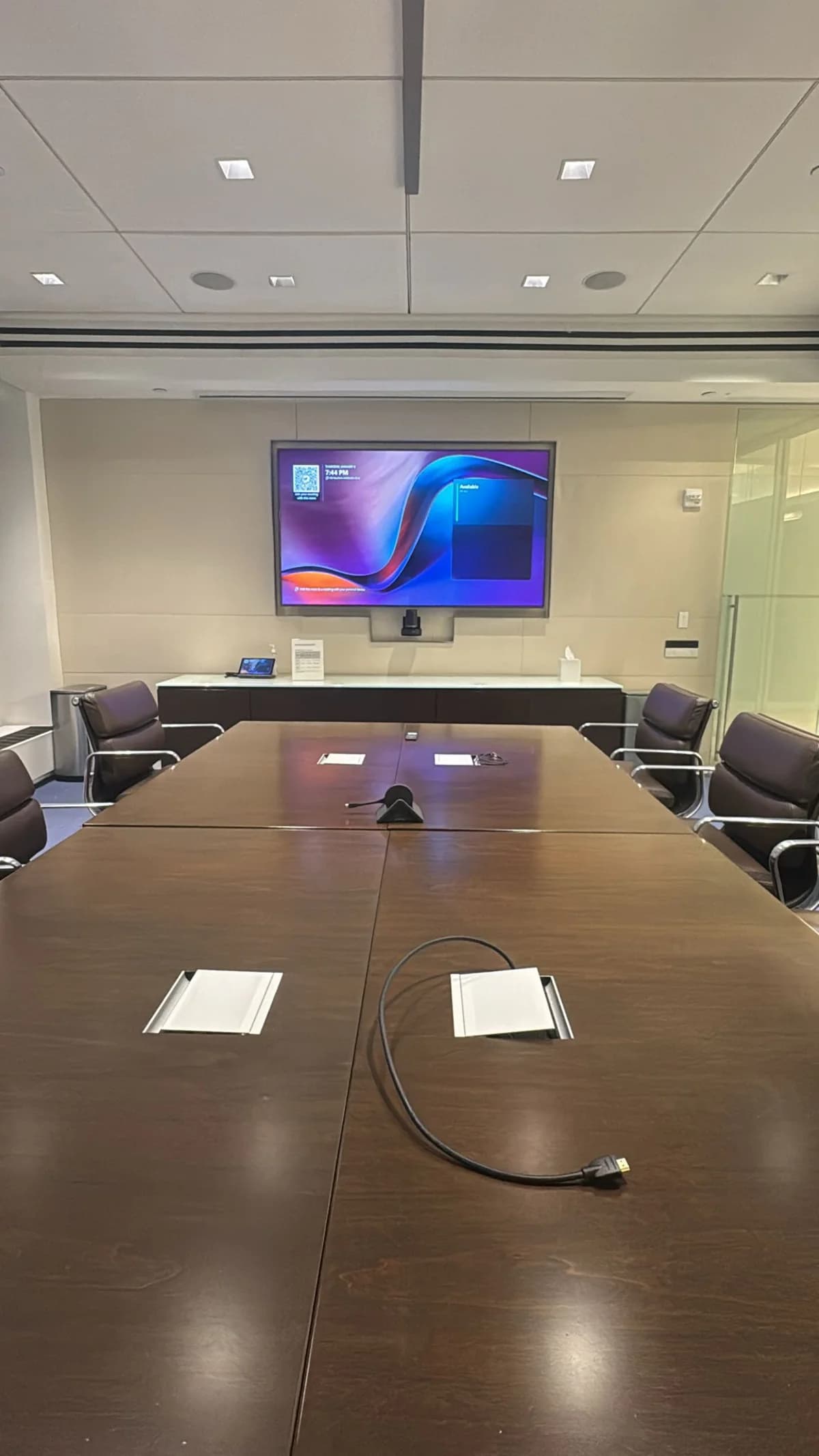 Conference room with a wall-mounted display and room controller
