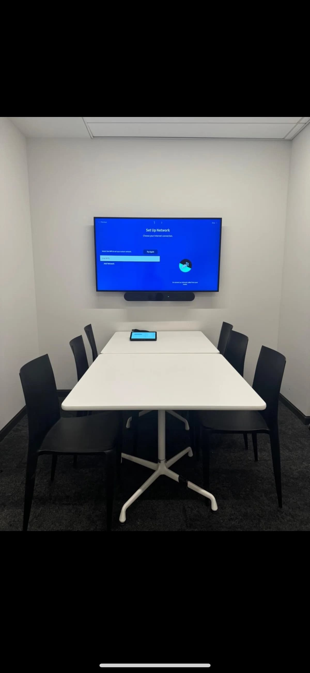 Small huddle room with a mounted display and all-in-one video bar