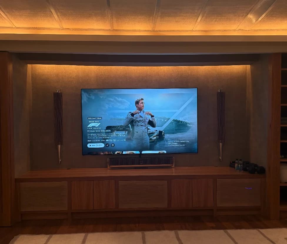 Cove-lit walnut media wall with a large flat-panel TV