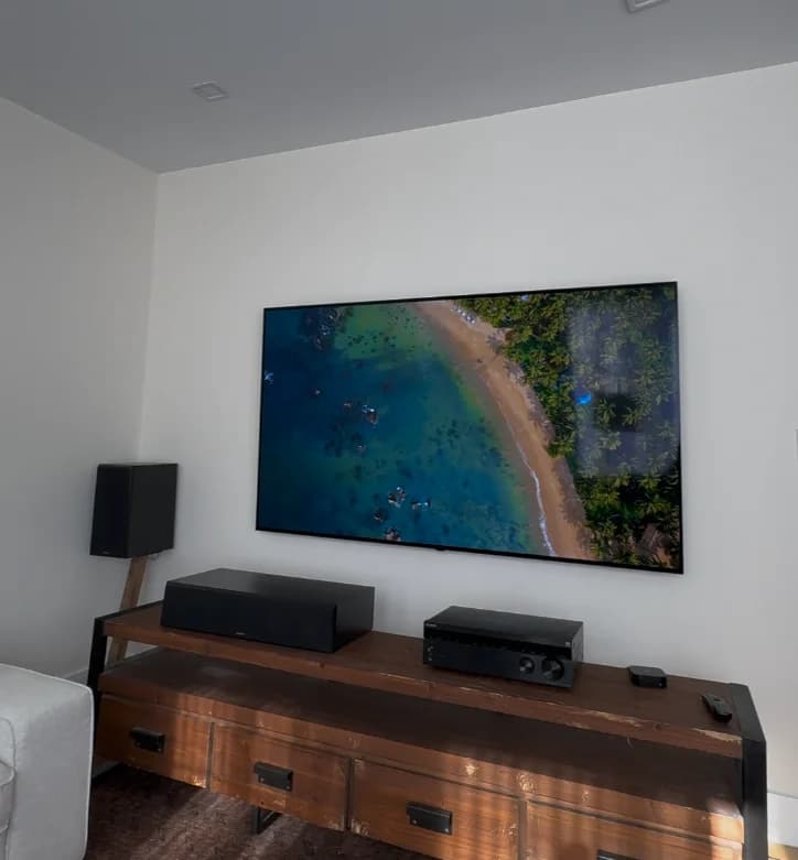 Large TV professionally mounted above a media console