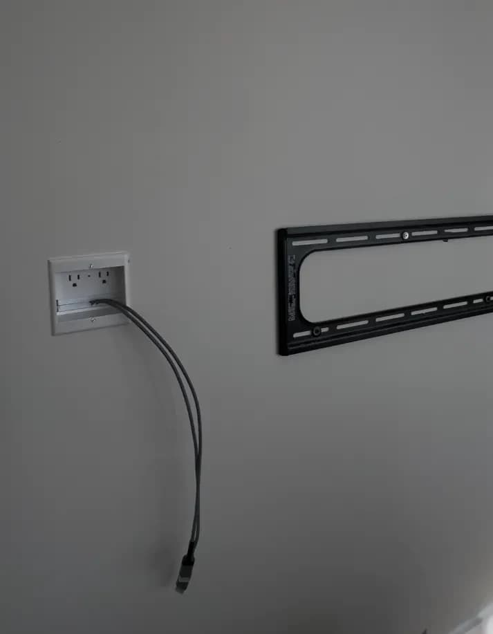 In-wall recessed power outlet and HDMI cable routed to TV bracket for a clean no-cord installation