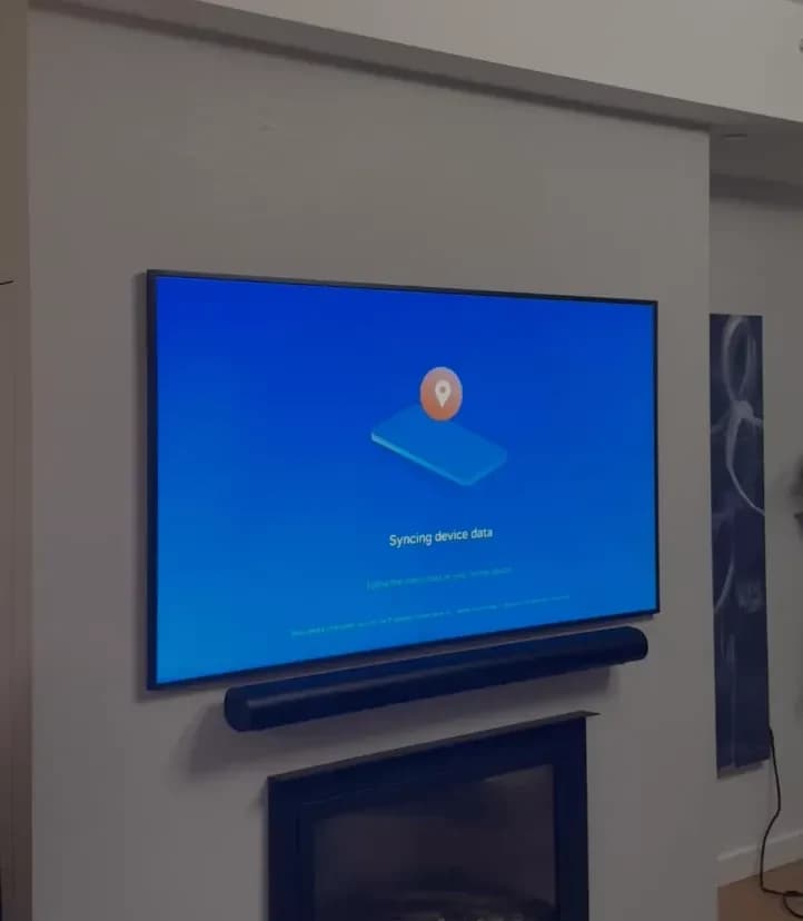TV mounted above a fireplace with soundbar and cables fully hidden in the drywall