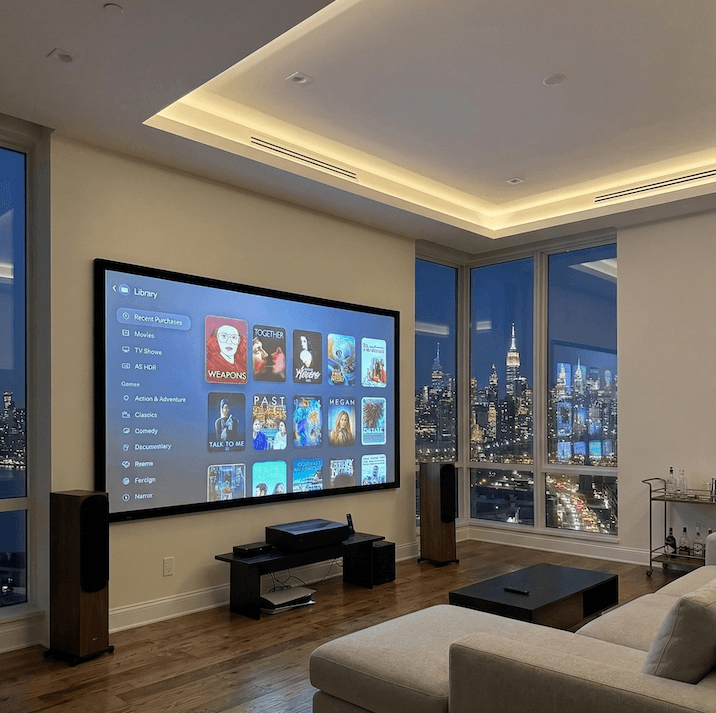 Luxury home theatre with large projection screen, tower speakers and cove LED lighting overlooking the NYC skyline