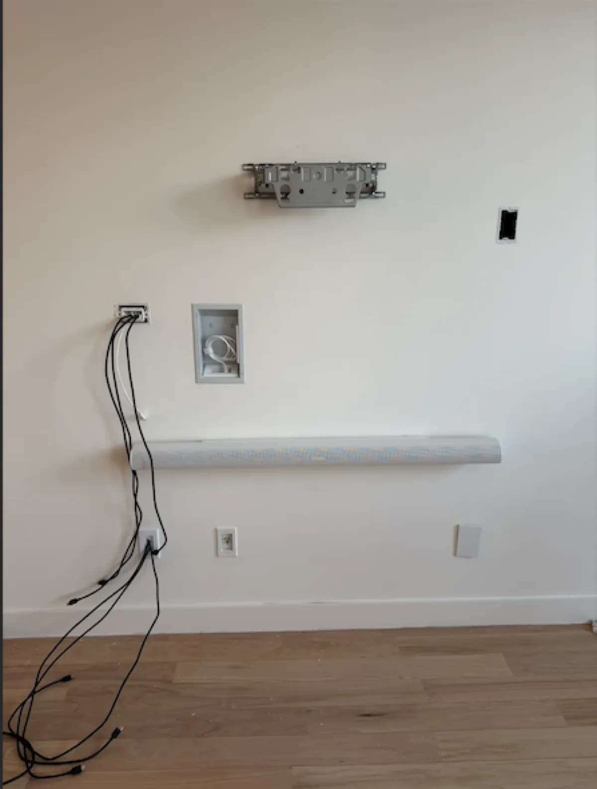 Samsung Frame TV mounting prep showing wall bracket and recessed in-wall cable box before installation