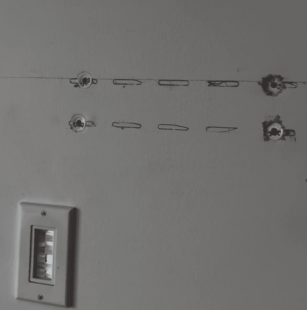 Wall after TV dismounting showing exposed anchor holes ready for patching