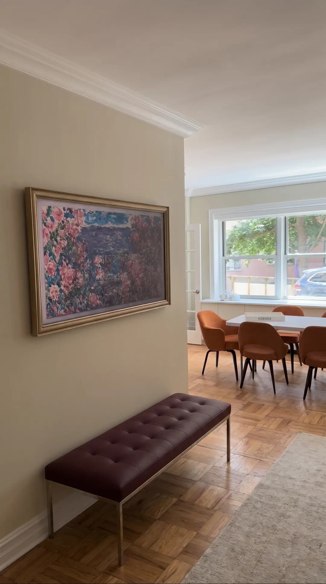 Wall-mounted TV in Art Mode showing a floral painting in an NYC apartment entryway