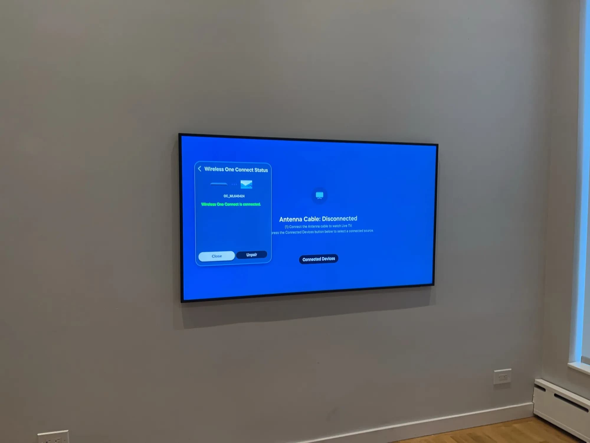 A wall-mounted TV showing a wireless connection status screen.