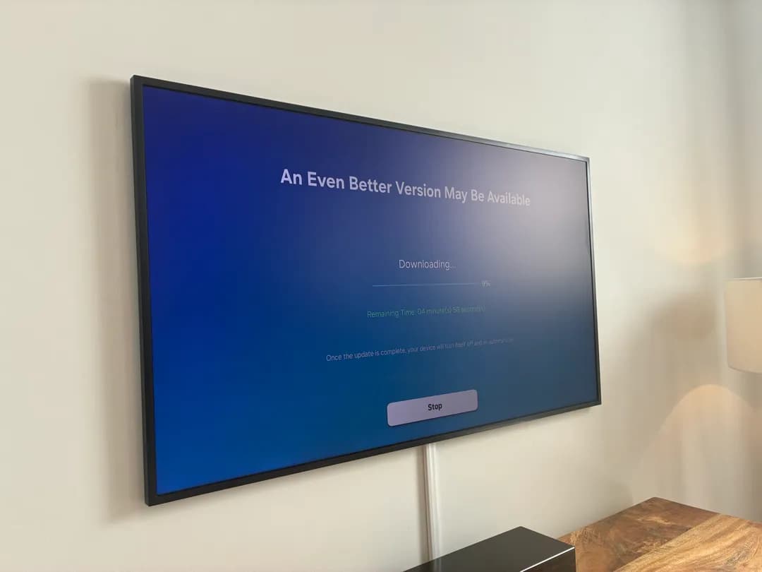 A wall-mounted TV with a white cord cover running down to a wooden console.